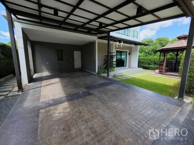 独立式住宅 出租在Prawet, Bangkok - 带顶双车位车棚，旁有草坪与木质花园凉亭。