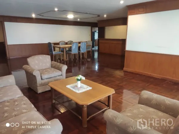 房间 出租在Watthana, Bangkok - 开放式客餐厅，沙发组、餐桌与木地板。