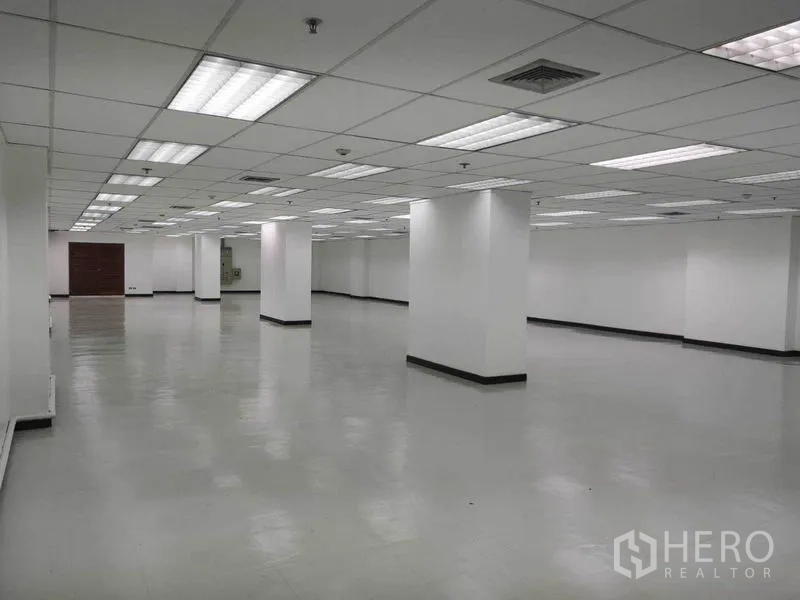 Office Space for rent in Phaya Thai, Bangkok - Empty open workspace with structural columns, vented ceiling and smooth reflective flooring.