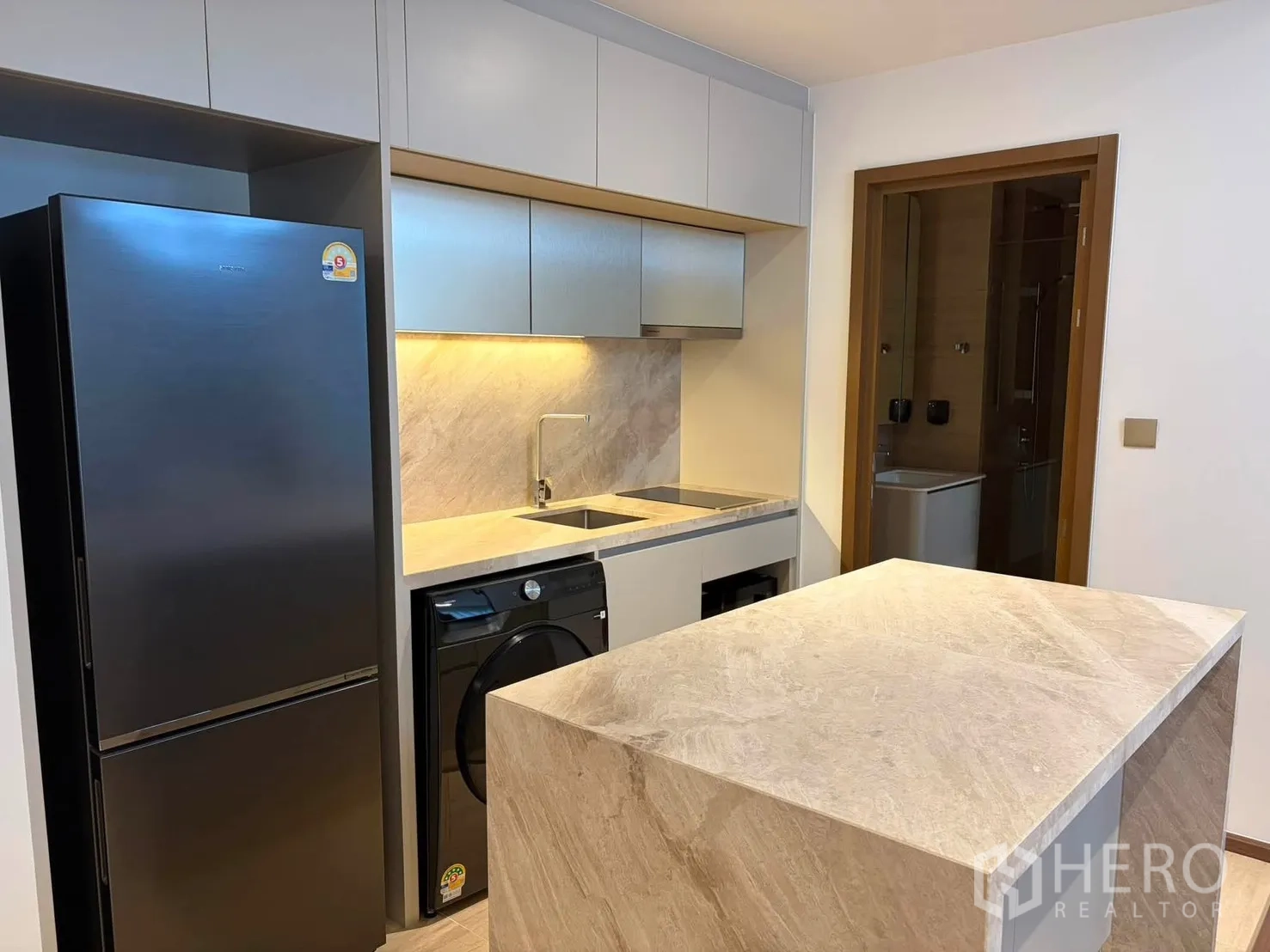 คอนโด for rent in Watthana, Bangkok - ครัวกะทัดรัดพร้อมไอส์แลนด์หิน อ่างล้างจาน ไฟใต้ตู้ ตู้เย็น และเครื่องซักผ้า