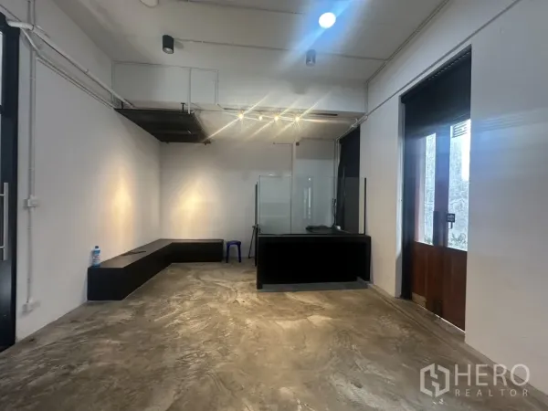 带办公室的家 出租在Pathum Wan, Bangkok - 一层零售/接待空间，水泥地面、接待台与玻璃门。