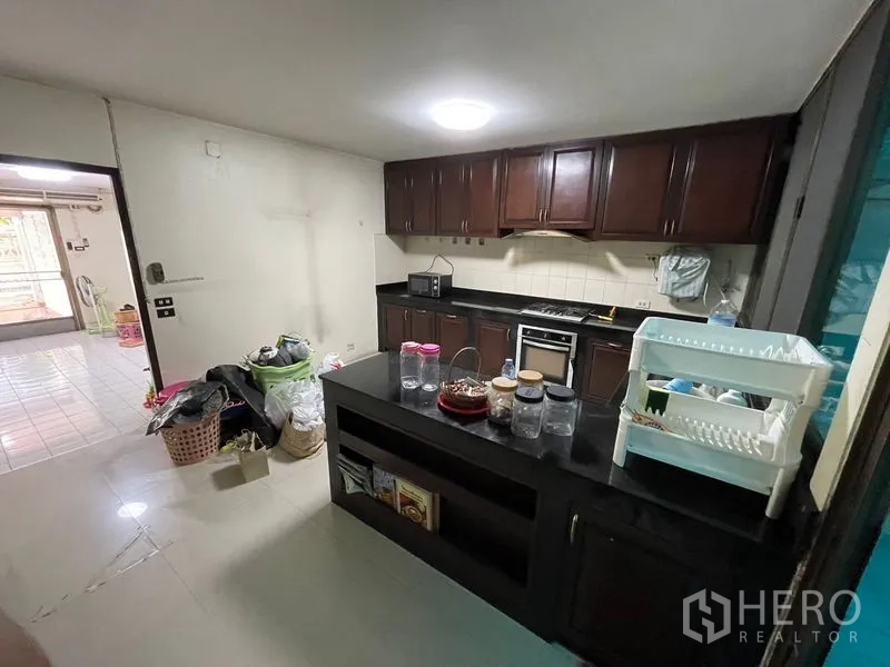 Home Office for rent in Watthana, Bangkok - Kitchen view toward entrance with island counter and ample cabinetry.