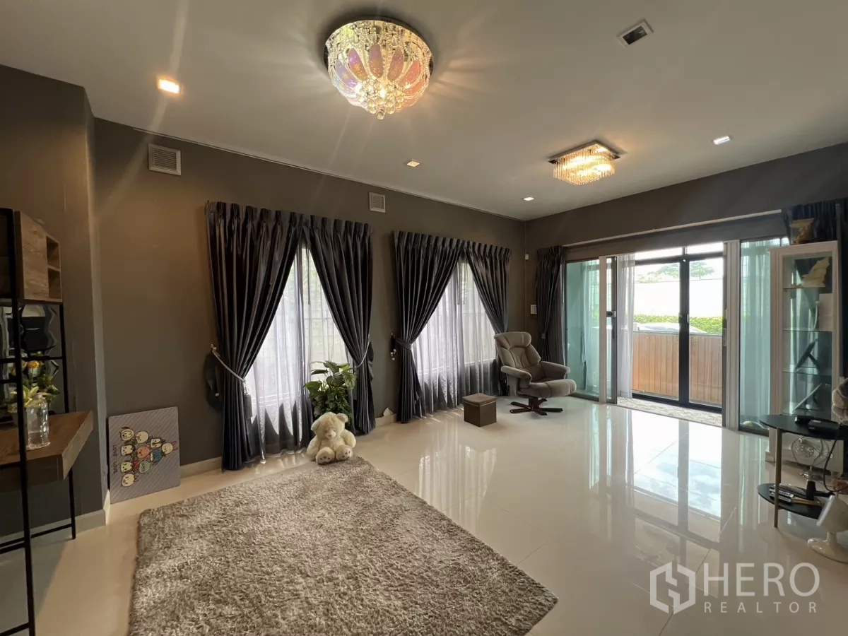独立式住宅 出租或出售在Lat Krabang, Bangkok - 宽敞客厅，玻璃滑门通向门廊，地毯温馨