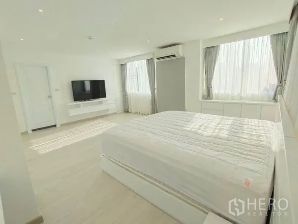 公寓 出租在Bang Rak, Bangkok - 主卧明亮，设大窗、壁挂电视与空调。