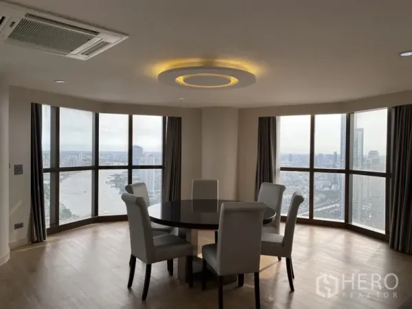 公寓 出租在Bang Rak, Bangkok - 转角餐区设圆桌四椅，环幕落地窗俯瞰湄南河全景。