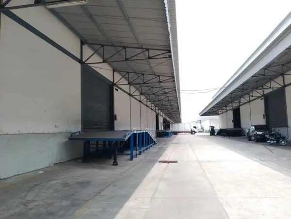 货栈 出租在Bang Phli, Samut Prakan - 带顶装卸区，卷帘门与蓝色钢制登车桥，通道宽阔可供卡车出入。