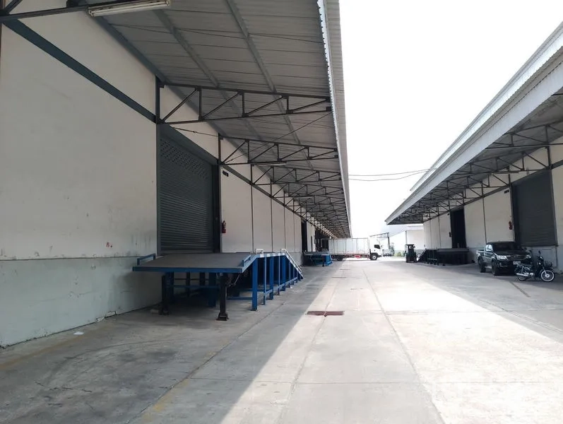 货栈 出租在Bang Phli, Samut Prakan - 带顶装卸区，卷帘门与蓝色钢制登车桥，通道宽阔可供卡车出入。