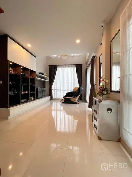 独立式住宅 出售在Prawet, Bangkok - 明亮起居室，亮面地砖、落地窗帘与内置展示柜。