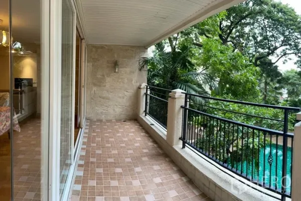 Condominium for rent in Watthana, Bangkok - Covered tiled balcony with wrought-iron railing overlooking greenery and the swimming pool.