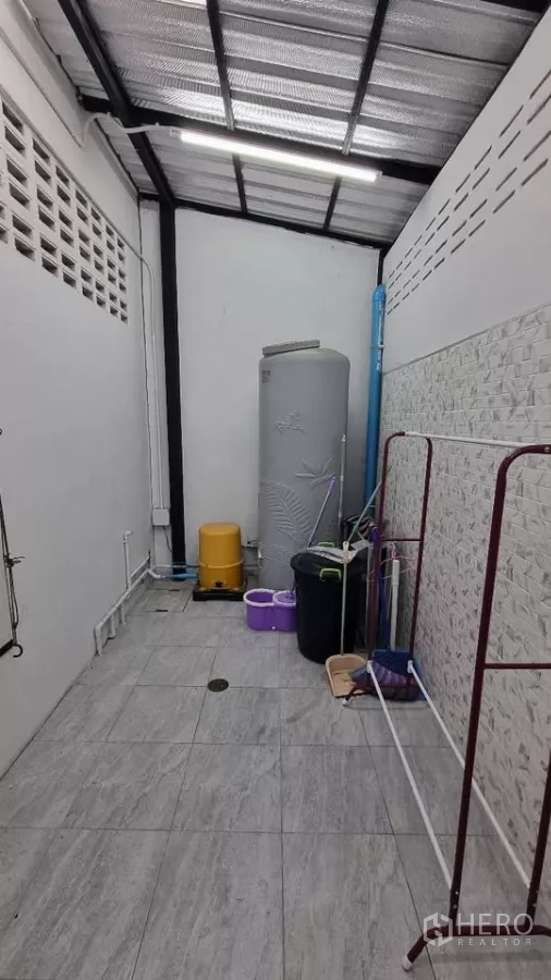 Townhouse for rent in Huai Khwang, Bangkok - Covered utility area with water tank and cleaning equipment.