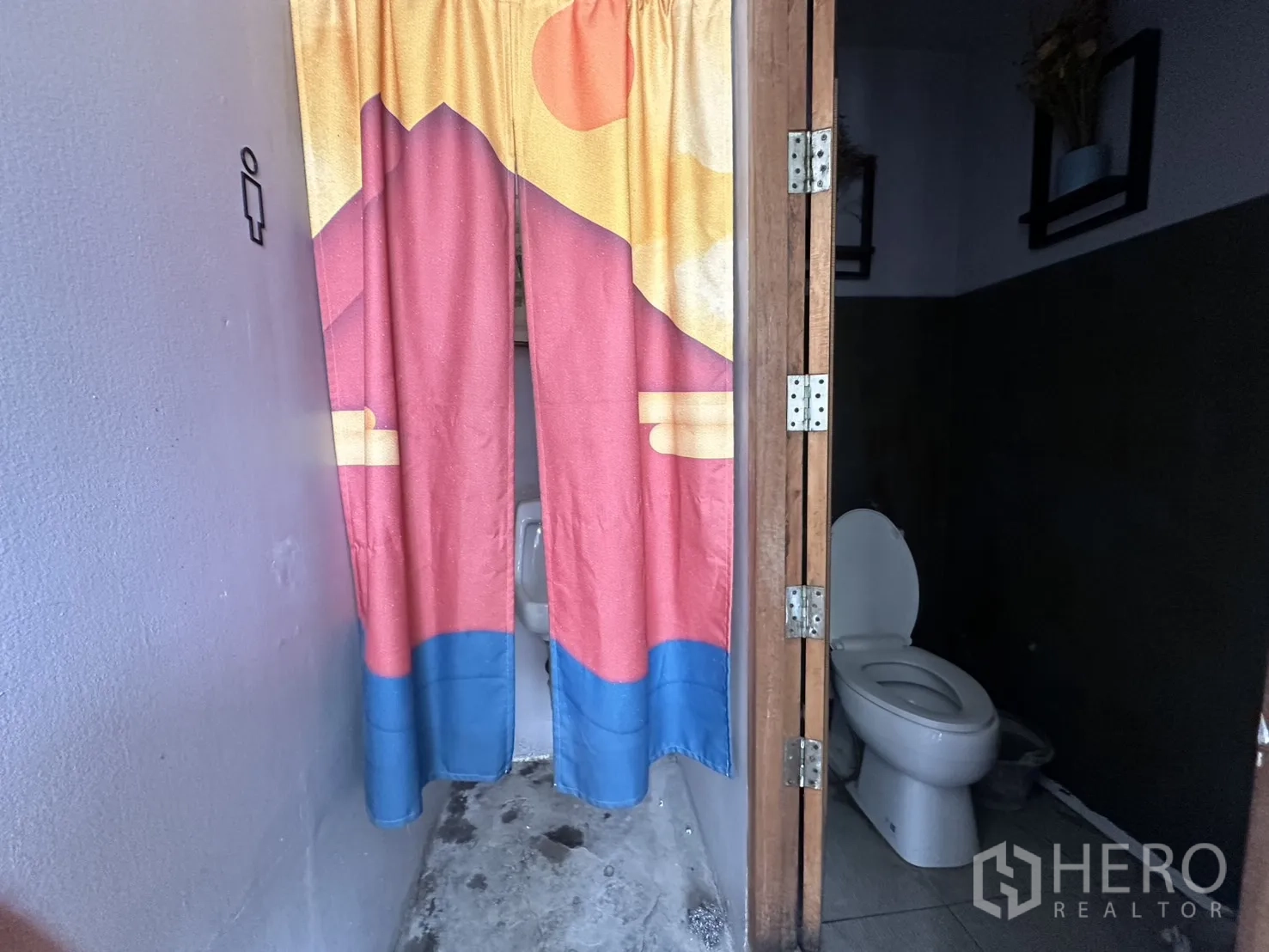 零售空间 for rent in Sathon, Bangkok - 小型卫生间，坐便器、瓷砖地面与彩色布帘隔断。