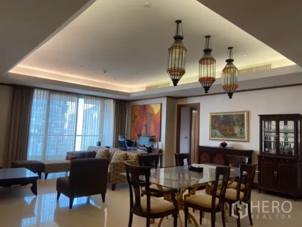 公寓 出租在Sathon, Bangkok - 开放式客餐厅，吊灯与灯槽天花，落地窗与木质柜体。