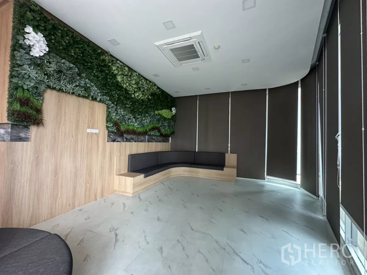 Retail Space for rent in Phra Khanong, Bangkok - Fitted lobby with green feature wall, curved built‑in bench, cassette AC and blackout blinds in Phra Khanong retail space.