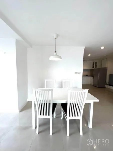 公寓 出租在Watthana, Bangkok - 简约餐区，白色餐桌配四把椅子，顶部吊灯照明。