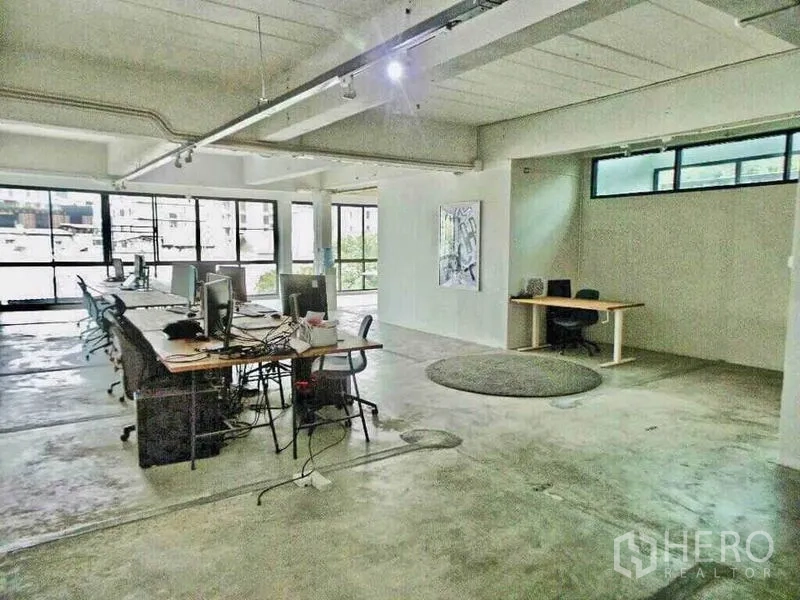 Home Office for rent or sale in Din Daeng, Bangkok - Expansive office floor with rows of workstations, track lighting and floor-to-ceiling windows.