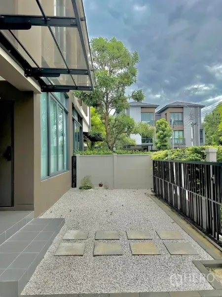 独立式住宅 出租或出售在Prawet, Bangkok - 前院碎石庭院，玻璃遮雨棚与栅栏门，临园景街道。