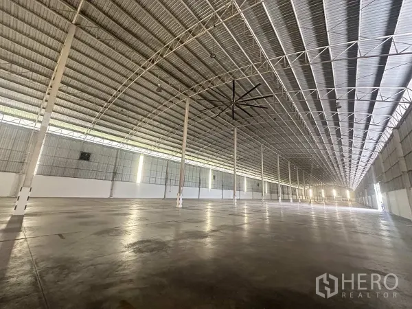 Warehouse for rent in Bang Pa-in, Phra Nakhon Si Ayutthaya - Long-span warehouse hall with rows of columns, high ceiling and industrial ceiling fan.
