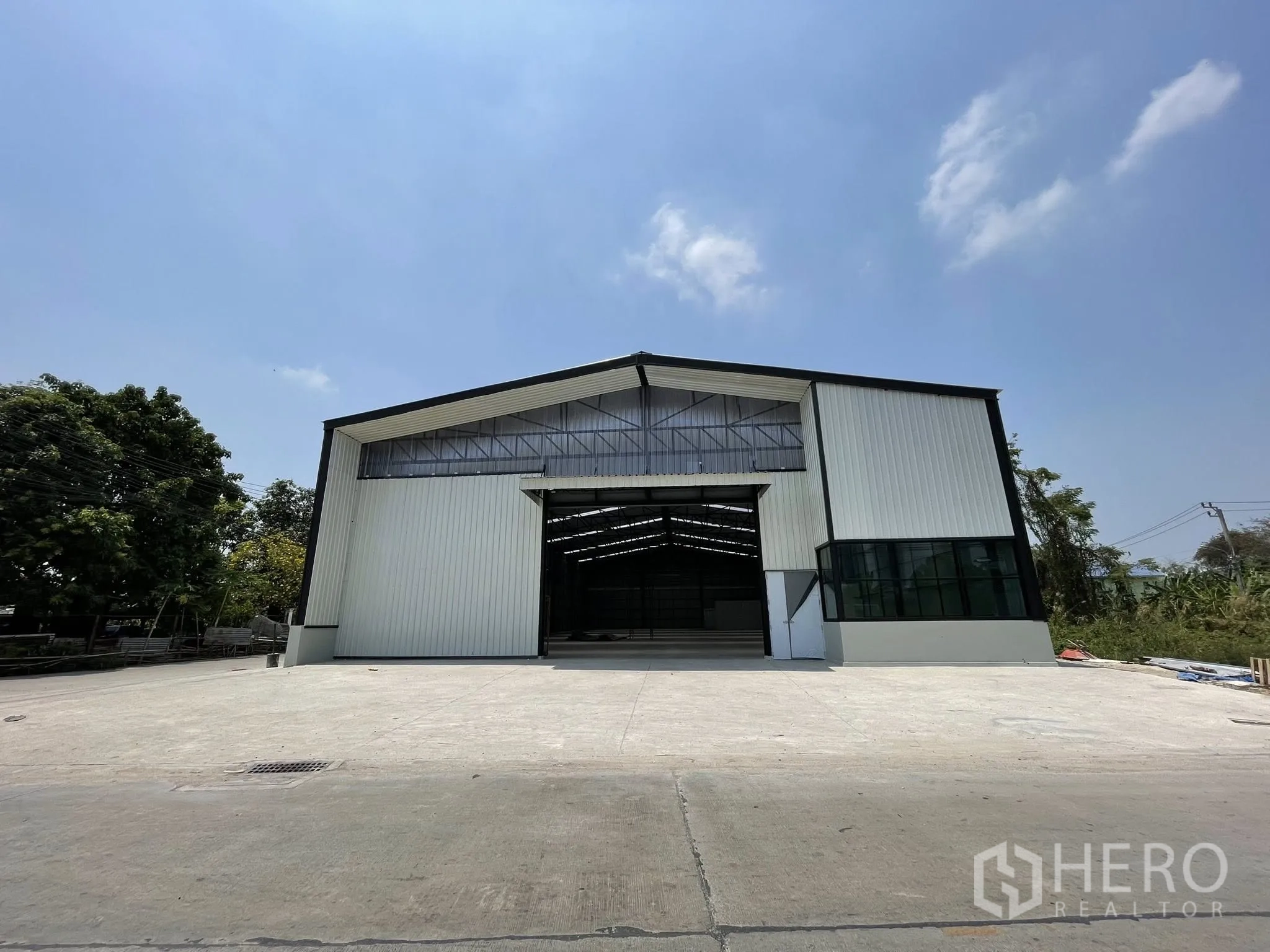 โกดัง for rent in Pak Kret, Nonthaburi - มุมหน้าอาคารเห็นลานคอนกรีตกว้างสำหรับจอดและขนถ่าย