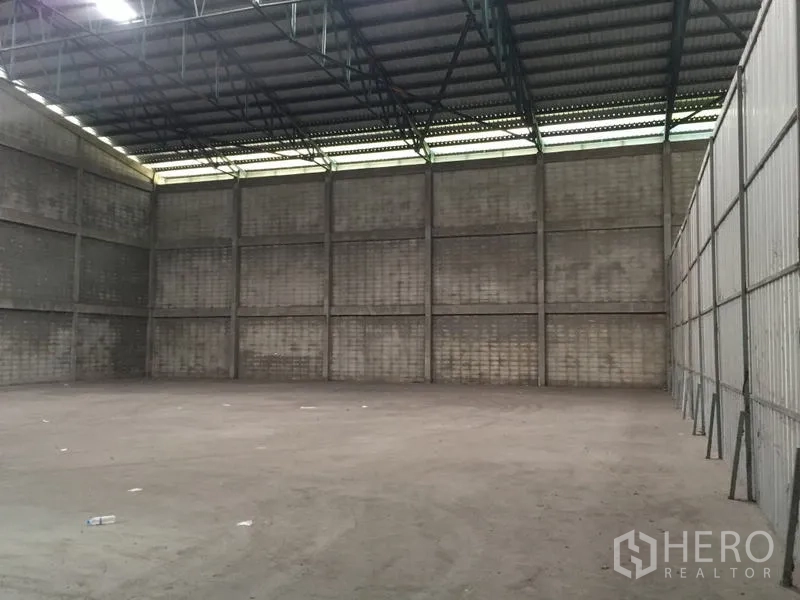Warehouse for rent in Mueang Pathum Thani, Pathum Thani - Empty warehouse bay showing tall walls and a wide open floor area.