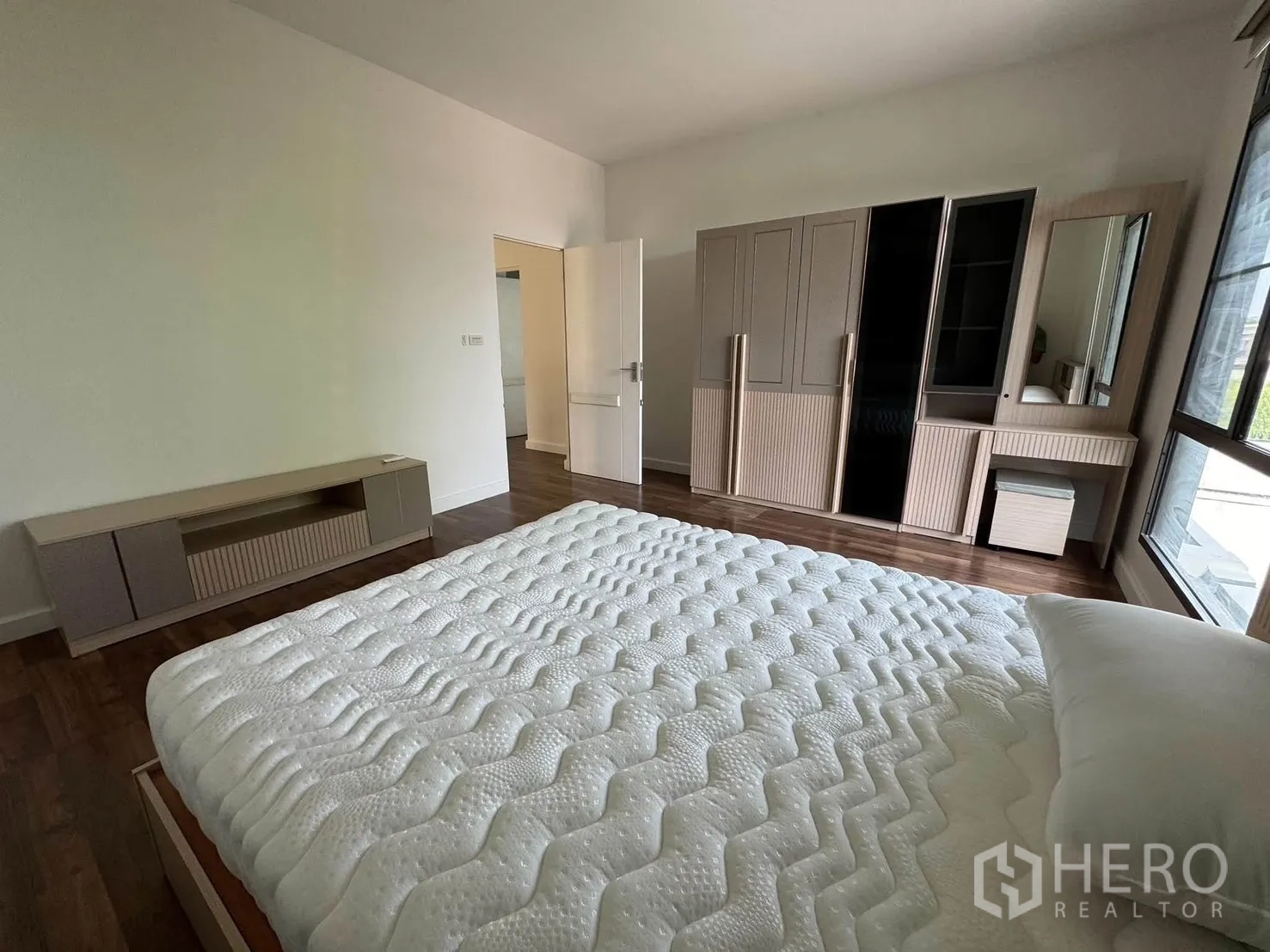 Detached House for rent in Prawet, Bangkok - Bedroom with bed and full wardrobe set, dressing table, and TV console.