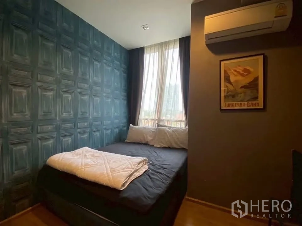 Condominium for rent in Watthana, Bangkok - Second bedroom with bed, air conditioner, and soft curtains by the window.
