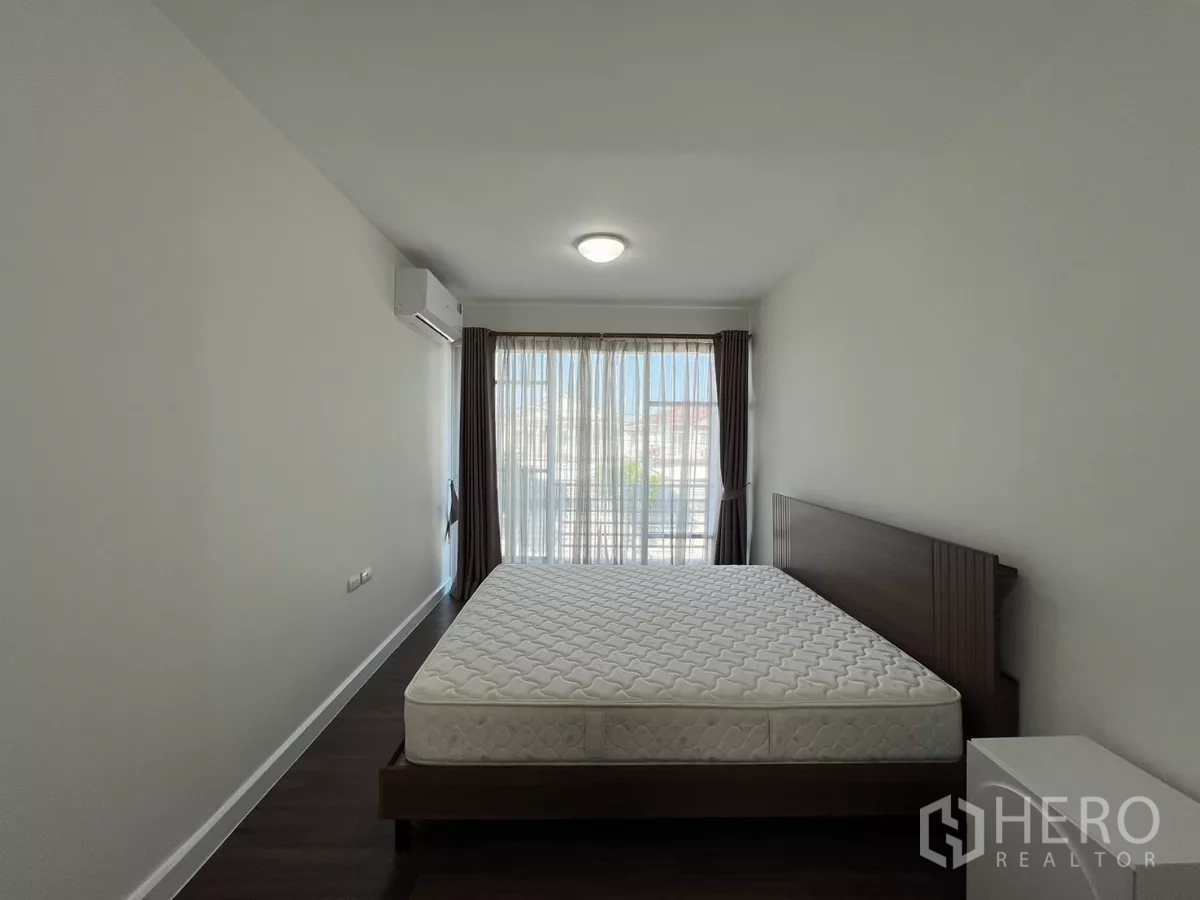 Townhouse for rent in Bang Kapi, Bangkok - Bedroom with balcony-style window and bed frame.