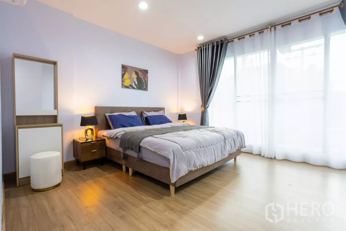 Townhouse for rent - Master bedroom with king bed, wood flooring and full-height curtains to balcony