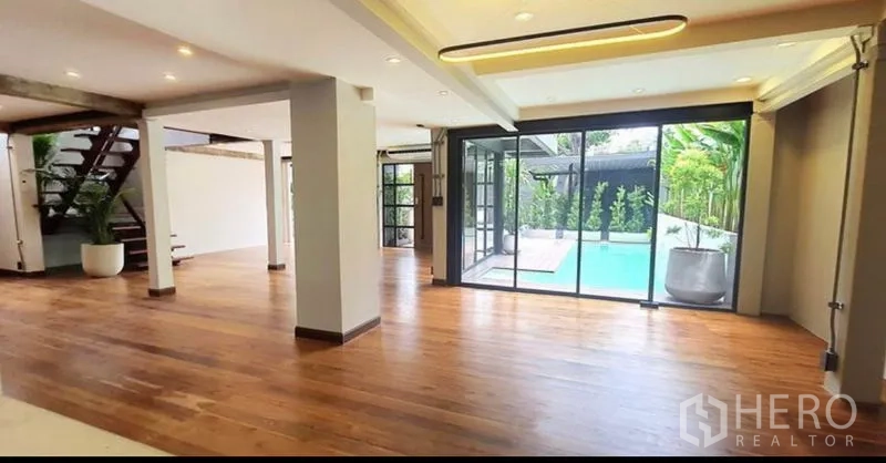 带办公室的家 出租或出售在Khlong Toei, Bangkok - 大型起居区，木地板，推拉门直通泳池平台。