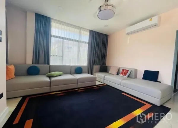 Detached House for sale in Sai Mai, Bangkok - Bright living room featuring large sectional sofas, sheer curtains, and air-conditioning.