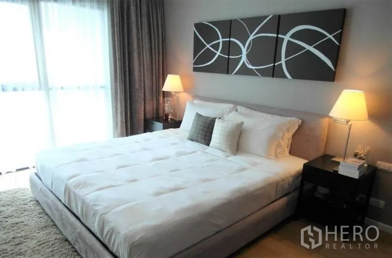 คอนโด ให้เช่าในSathon, Bangkok - ห้องนอนใหญ่เตียงคิงไซส์ โคมไฟหัวเตียง งานศิลป์ และหน้าต่างเต็มบานพร้อมม่านโปร่ง