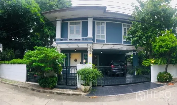 独立式住宅 出租在Bang Kapi, Bangkok - 正面全景，铁艺大门、铺砖车道与有顶停车区。