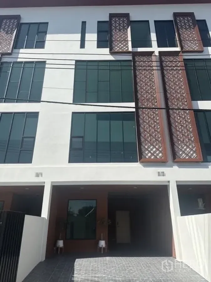 Home Office for rent in Wang Thonglang, Bangkok - Modern townhouse facade with tall windows and decorative lattice panels.
