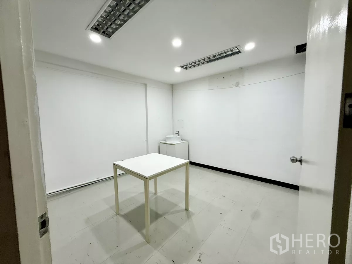 办公空间 出租在Din Daeng, Bangkok - 明亮办公室，配桌子、灯盘和小型洗手台柜。