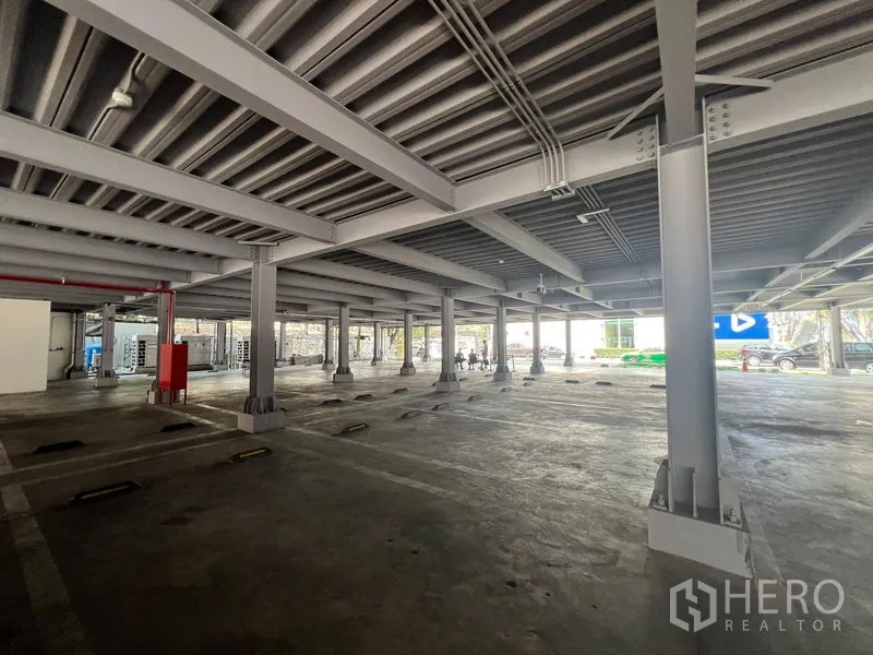 Retail Space for rent in Huai Khwang, Bangkok - Covered car park with steel columns, lighting and clearly marked parking bays at the retail complex.