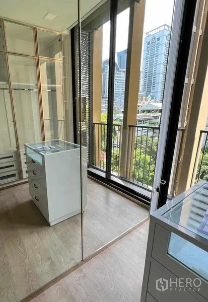 Condominium for rent in Watthana, Bangkok - Dressing room with balcony doors and skyline view over Sukhumvit.