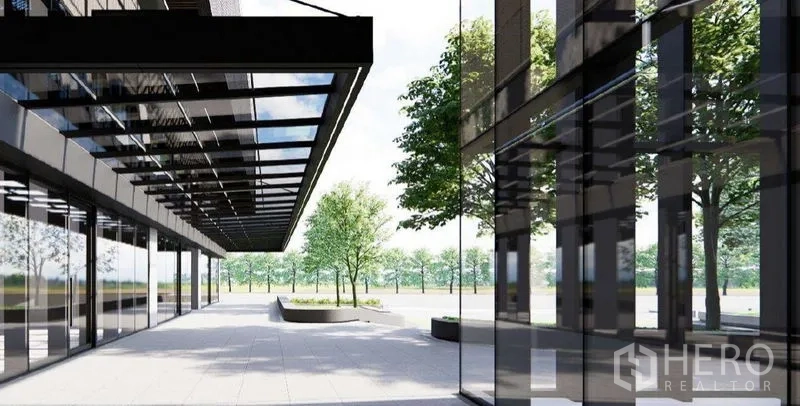 Retail Space for rent in Khlong Toei, Bangkok - Modern glass retail frontage with covered walkway and landscaped plaza with trees.