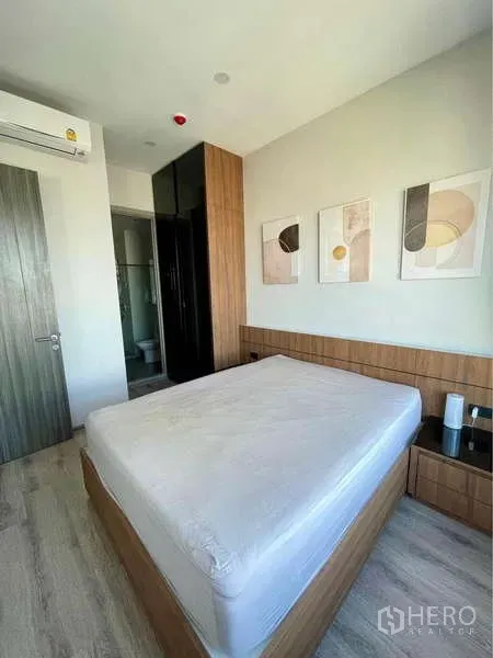 คอนโด ให้เช่าในWatthana, Bangkok - ห้องนอนใหญ่พร้อมหัวเตียงบิวท์อิน งานศิลป์บนผนัง ตู้เสื้อผ้า และห้องน้ำในตัว