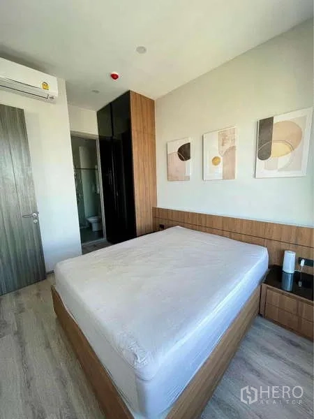 คอนโด ให้เช่าในWatthana, Bangkok - ห้องนอนใหญ่พร้อมหัวเตียงบิวท์อิน งานศิลป์บนผนัง ตู้เสื้อผ้า และห้องน้ำในตัว