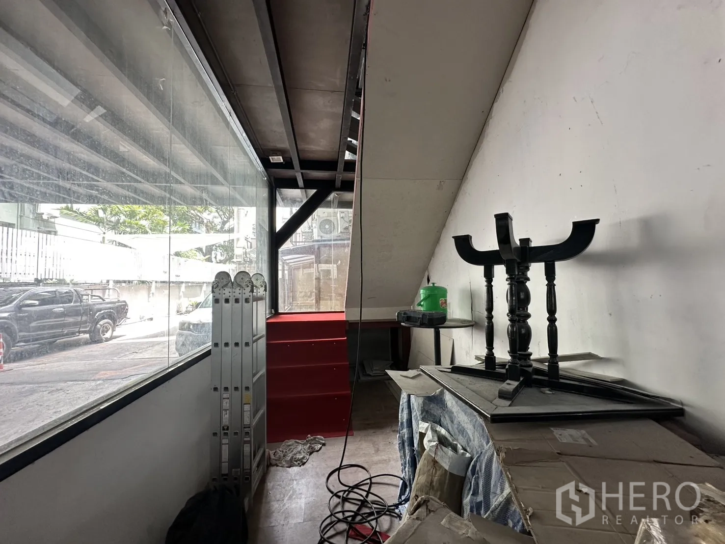 พื้นที่ขายของ for rent in Watthana, Bangkok - โถงแสดงสินค้าชั้นล่างติดกระจกเต็มบานและบันไดสีแดงขึ้นชั้นลอย.