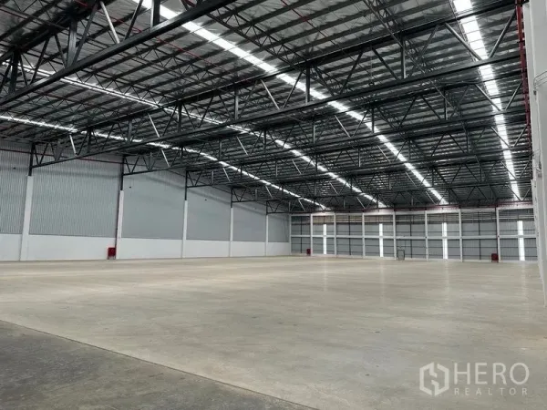 Warehouse for rent in Bang Phli, Samut Prakan - Expansive clear‑span warehouse with bright lighting and polished concrete floor.