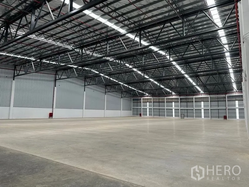 Warehouse for rent in Bang Phli, Samut Prakan - Expansive clear‑span warehouse with bright lighting and polished concrete floor.