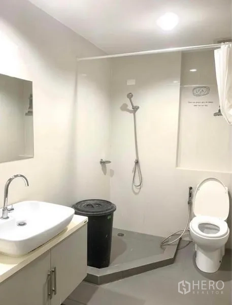 Townhouse for rent in Suan Luang, Bangkok - Clean bathroom with walk-in shower, toilet and vanity under recessed lighting.