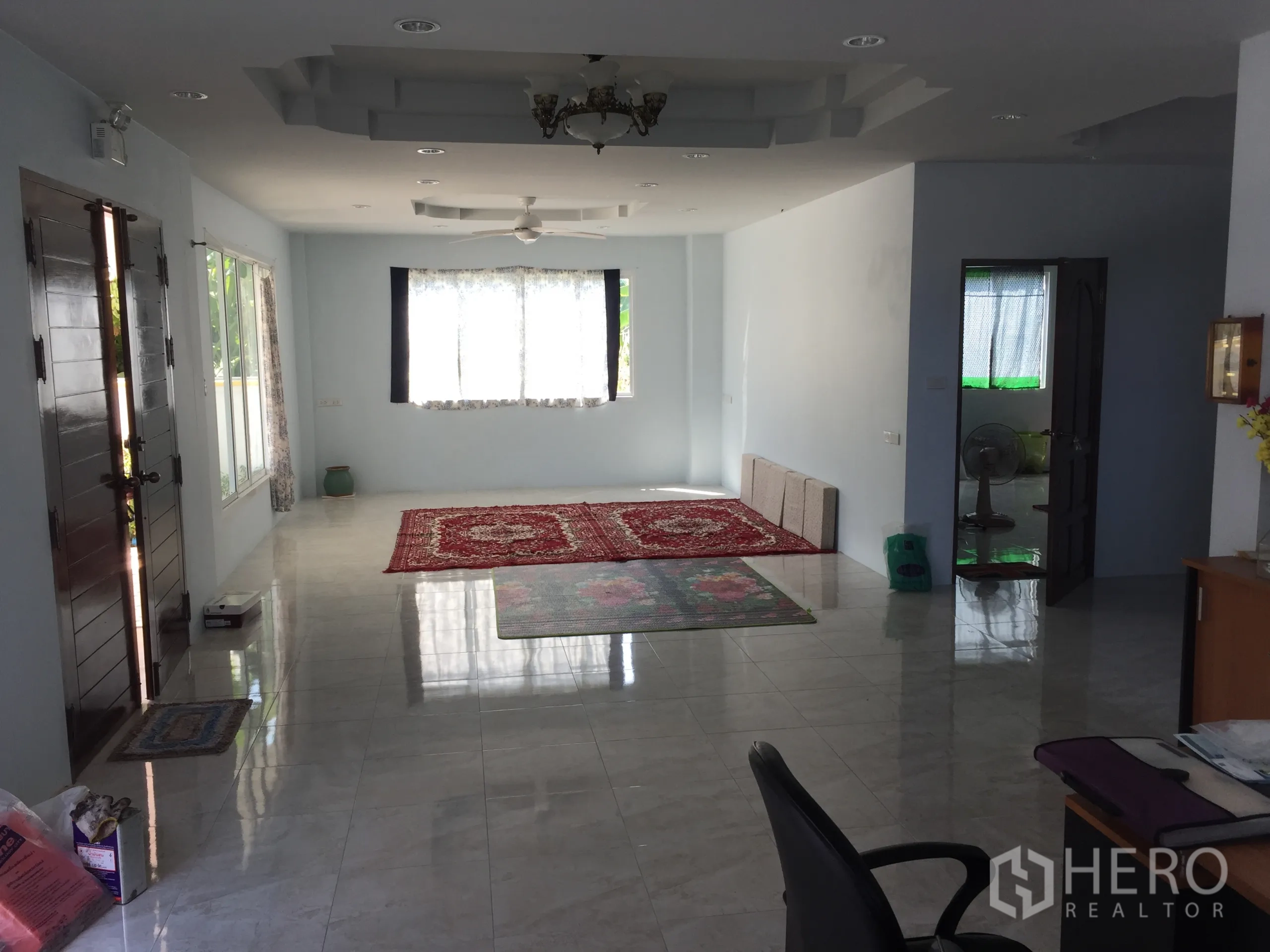独立式住宅 出租在Saphan Sung, Bangkok - 明亮宽敞的起居室，大窗户、光亮地面与前门视角。