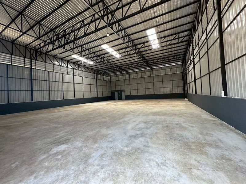 Warehouse for rent in Bueng Kum, Bangkok - Spacious clear-span warehouse interior with high steel-truss roof, skylights, and polished concrete floor.