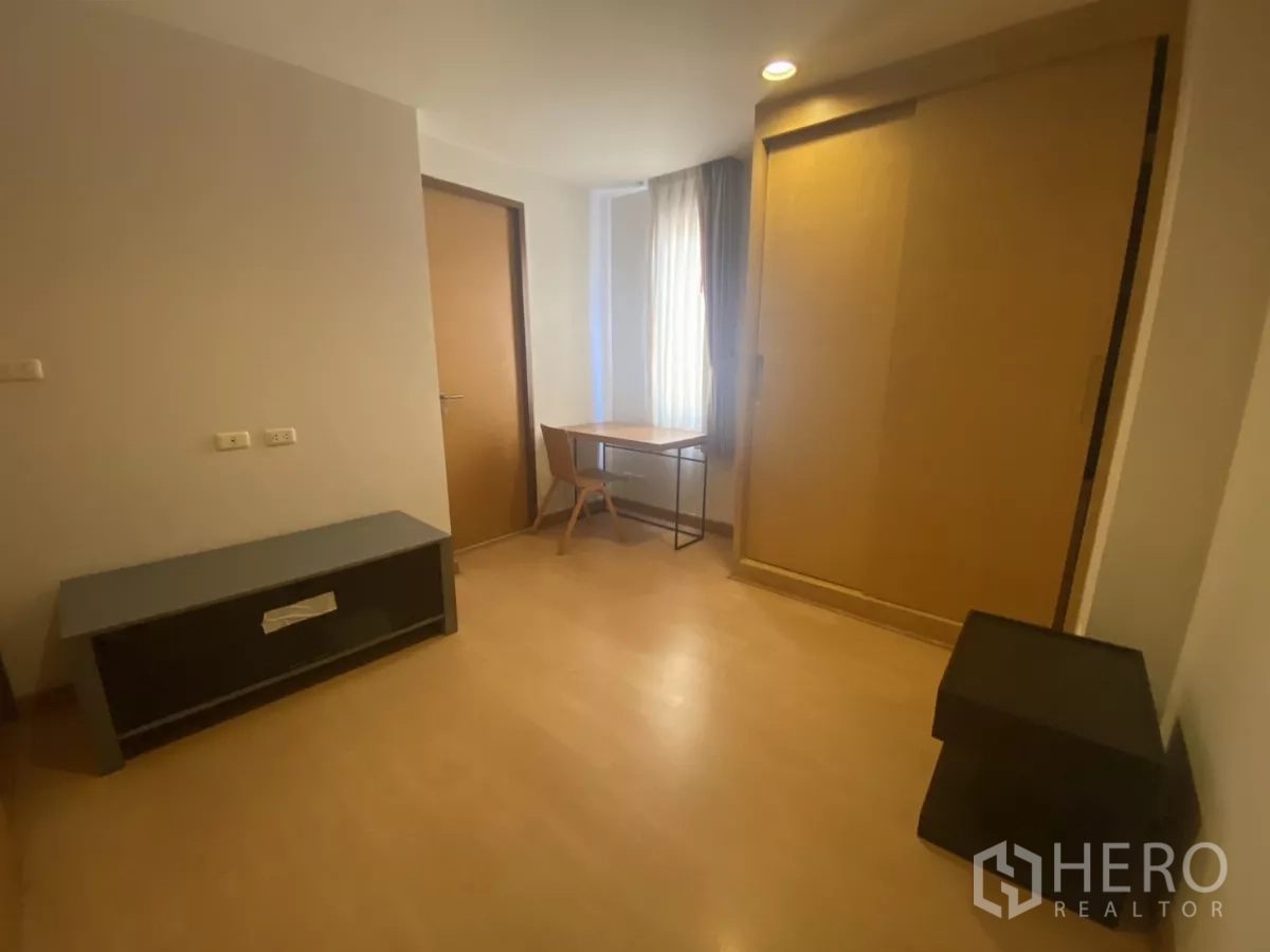 Condominium for rent in Watthana, Bangkok - Multipurpose room with desk, sliding-door wardrobe and wood floors.