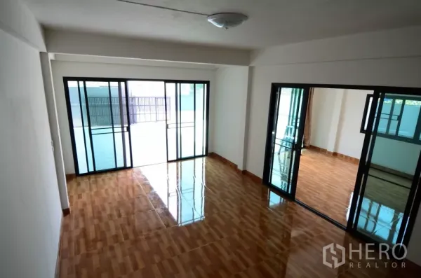 带办公室的家 出租在Lat Phrao, Bangkok - 一楼开放式空间，亮面木纹地砖与大面积推拉玻璃隔断。