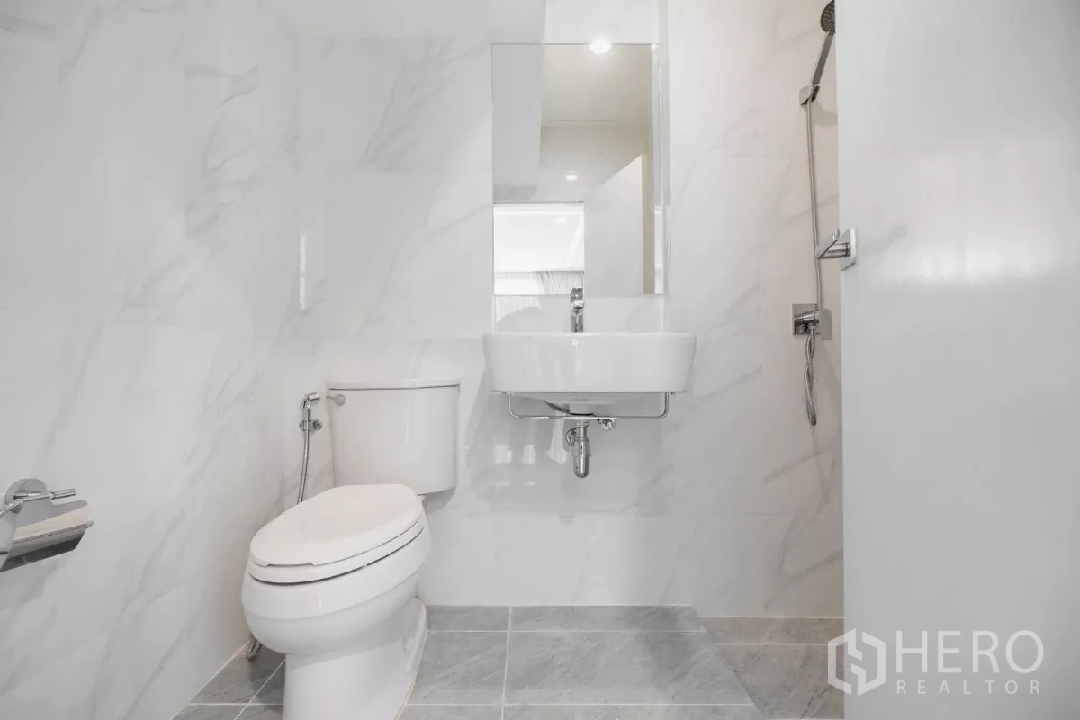 Detached House for rent or sale in Prawet, Bangkok - Guest bathroom with vanity, toilet and glass-door shower