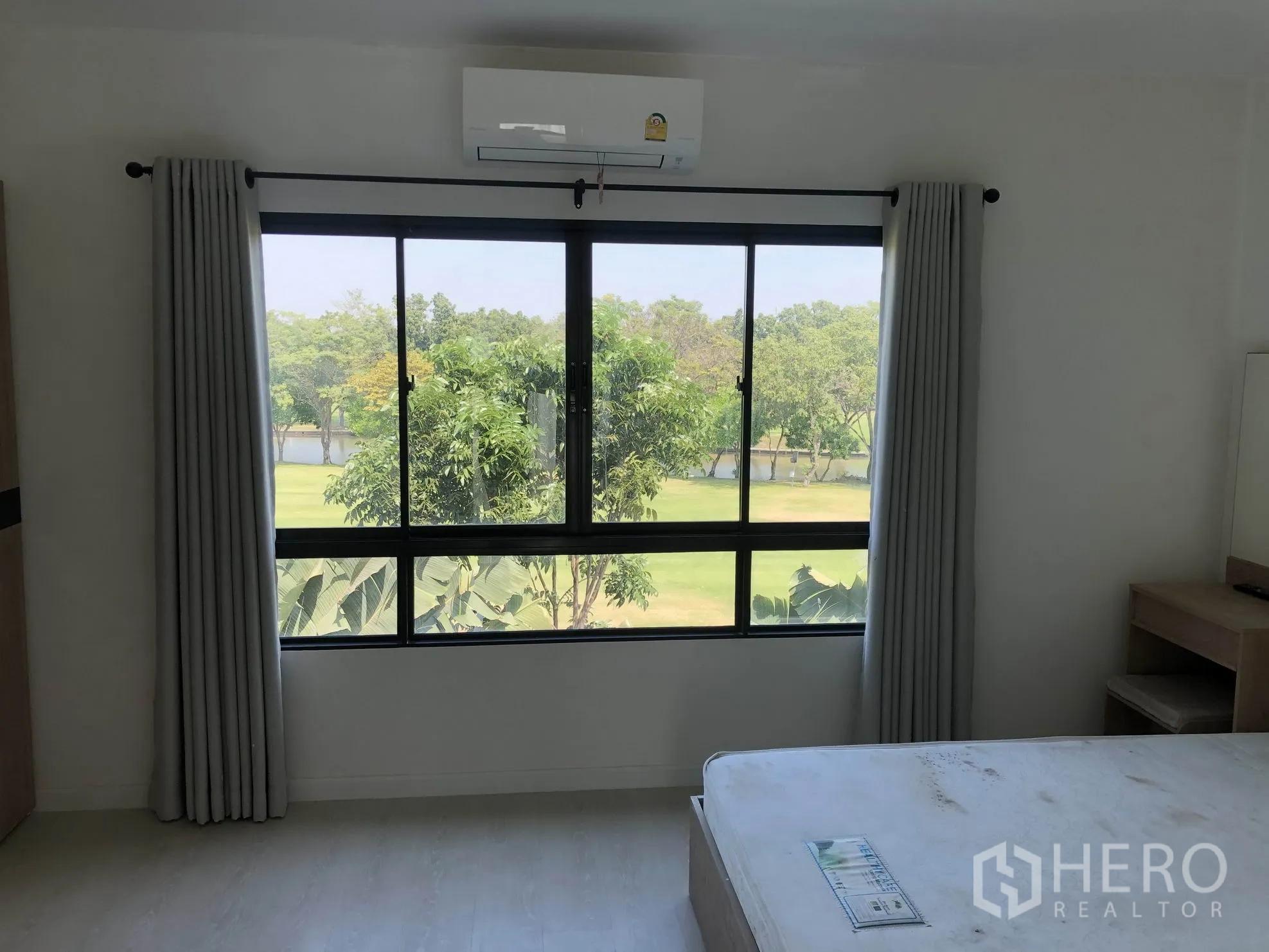 联排别墅 出租在Bang Kapi, Bangkok - 主卧大窗框出公园与湖景，自然光充沛。