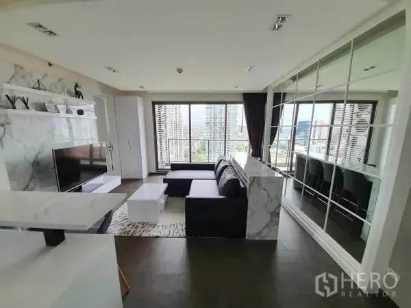 公寓 出租或出售在Watthana, Bangkok - 客厅朝向落地窗和阳台，享宽阔城市天际线