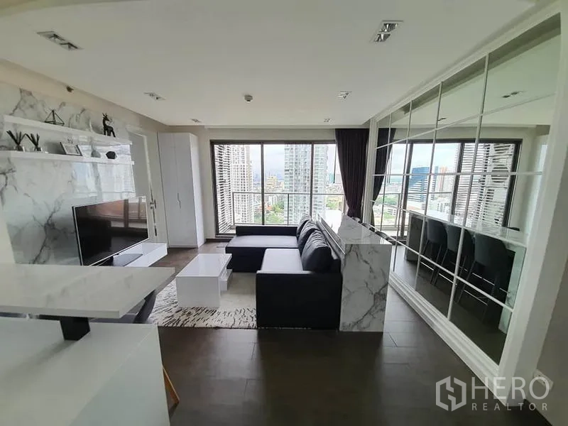 公寓 出租或出售在Watthana, Bangkok - 客厅朝向落地窗和阳台，享宽阔城市天际线